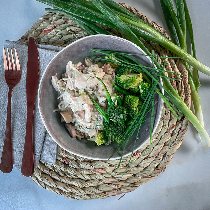 Chicken breast strips in creamy coconut with sautéed greens on a bed of caulirice